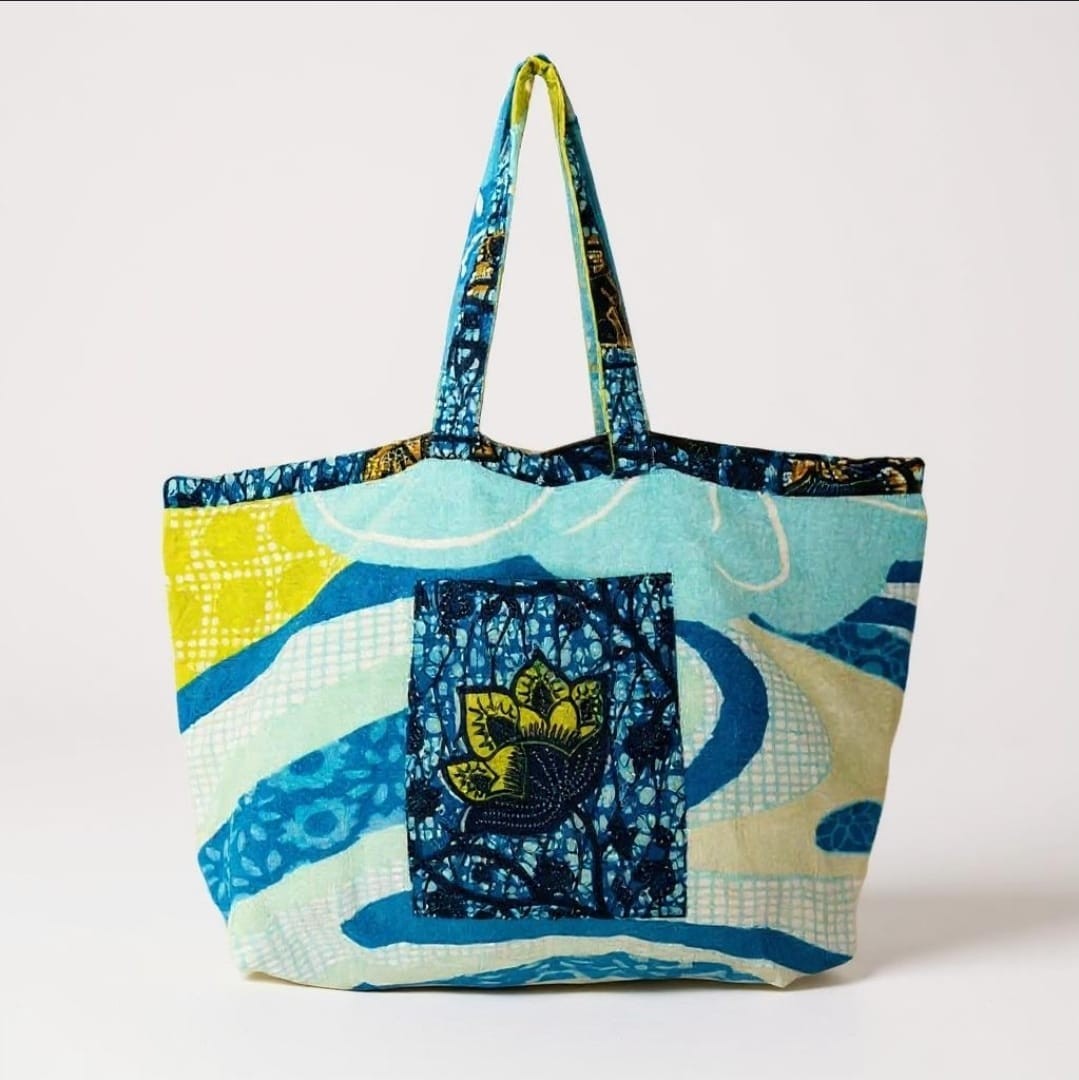 Handmade blue floral beach bag on sand
